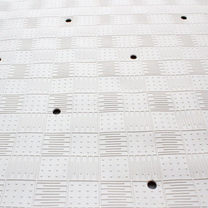 Flat close-up of the checkerboard pattern on the top of the large Compass bath mat with several drain holes