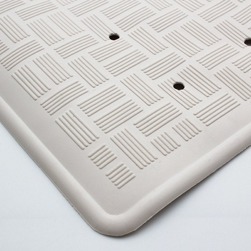 Close-up of the rounded rim on the small Compass rubber mat with the basket-weave texture and two drain holes