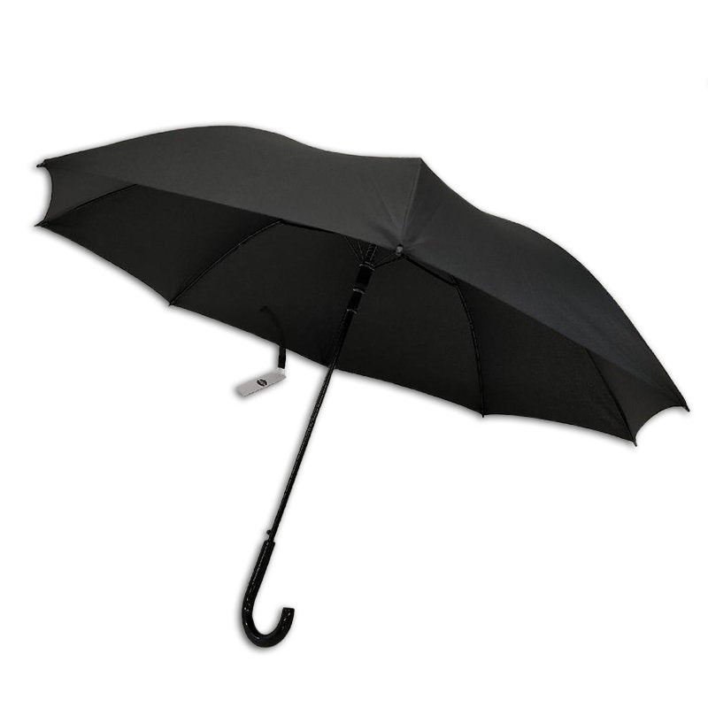 Standard black Compass umbrella open at an angle, showing the canopy, slim shaft, black crook handle and a white swing tag