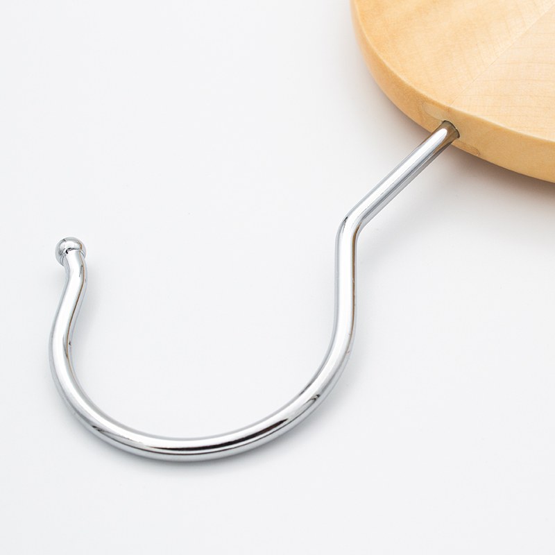 Close view of the chrome hook on the Compass hanger with its rounded tip, fixed into the light wood crown