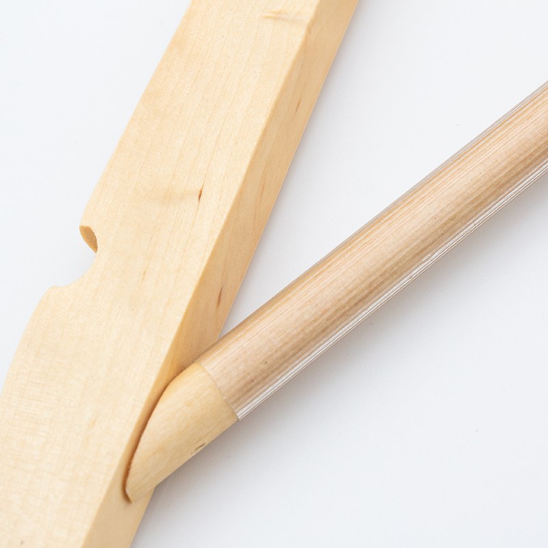 Close view of the clear PVC tube over the wooden rod of the Compass hanger where it joins the shoulder end