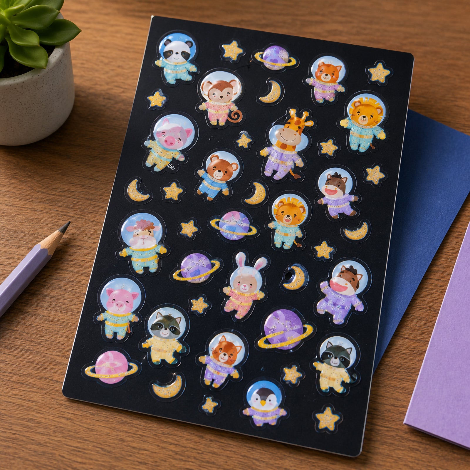 Full Cosmic Critters sticker sheet displayed on a dark background featuring astronaut animals, planets, stars and moons. The glow in the dark designs showcase a fun outer space theme suitable for children.
