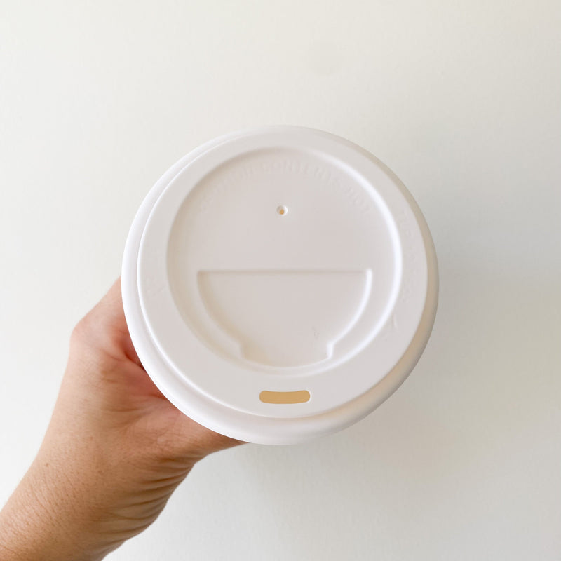 Angled view of the white PP recyclable takeaway lid showing the sip spout profile