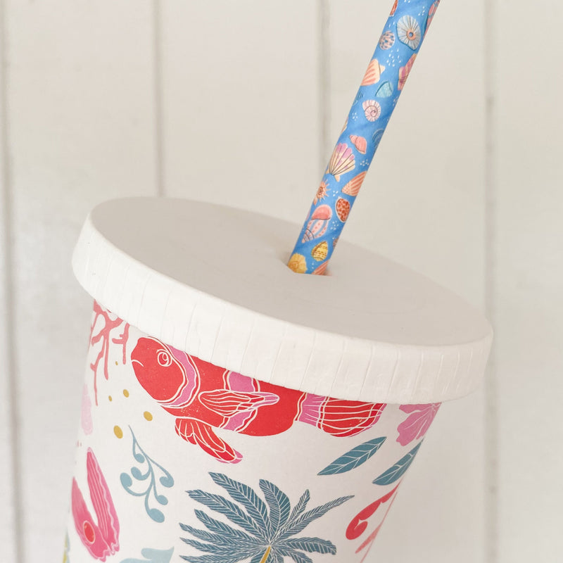 Flat paper cold lid with straw hole fitted to an iced latte cup