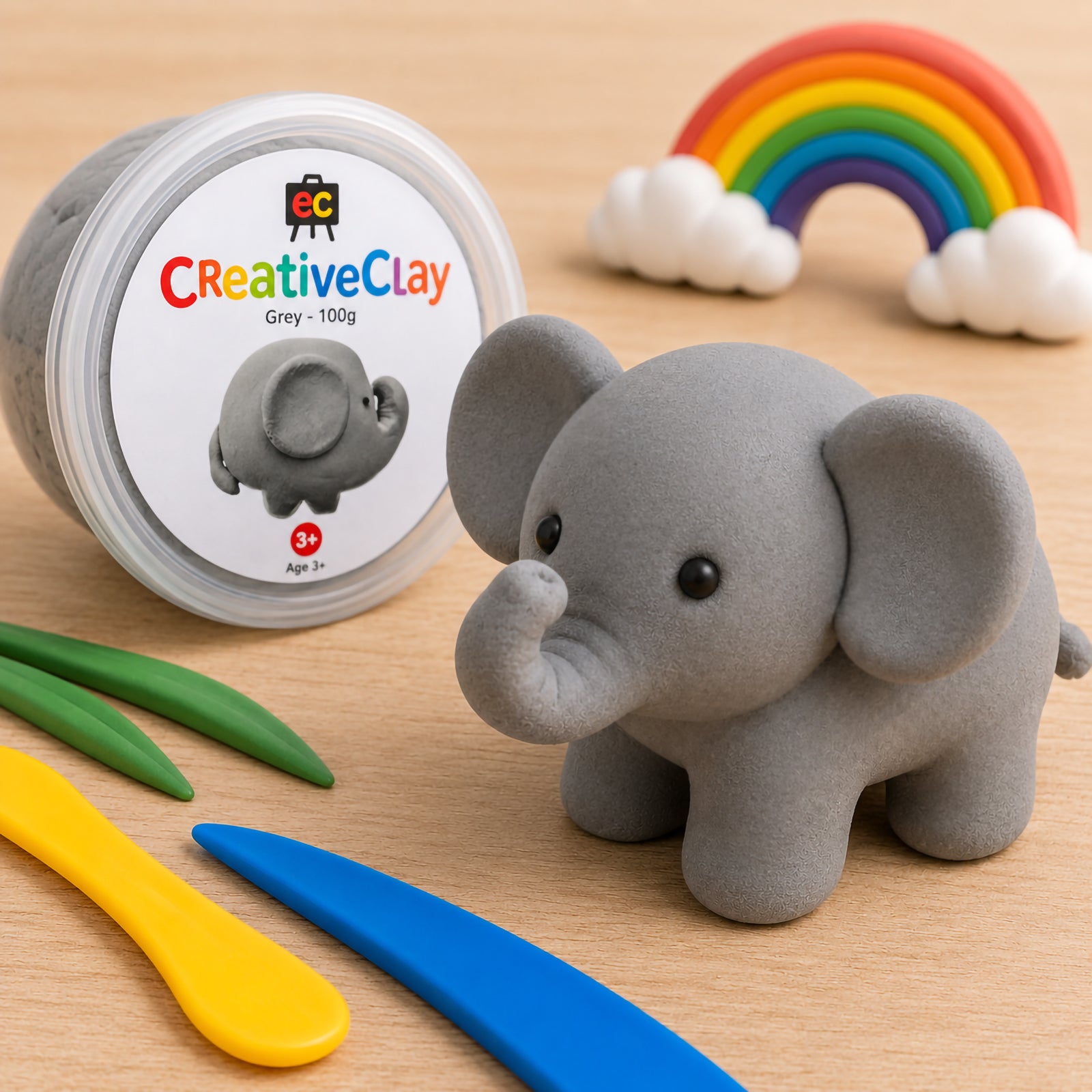 Educational Colours CreativeClay Grey 100g container displayed beside a completed elephant sculpture. Modelling tools, decorative greenery and colourful classroom elements showcase the clay's use in creative learning, sculpture projects and imaginative play.