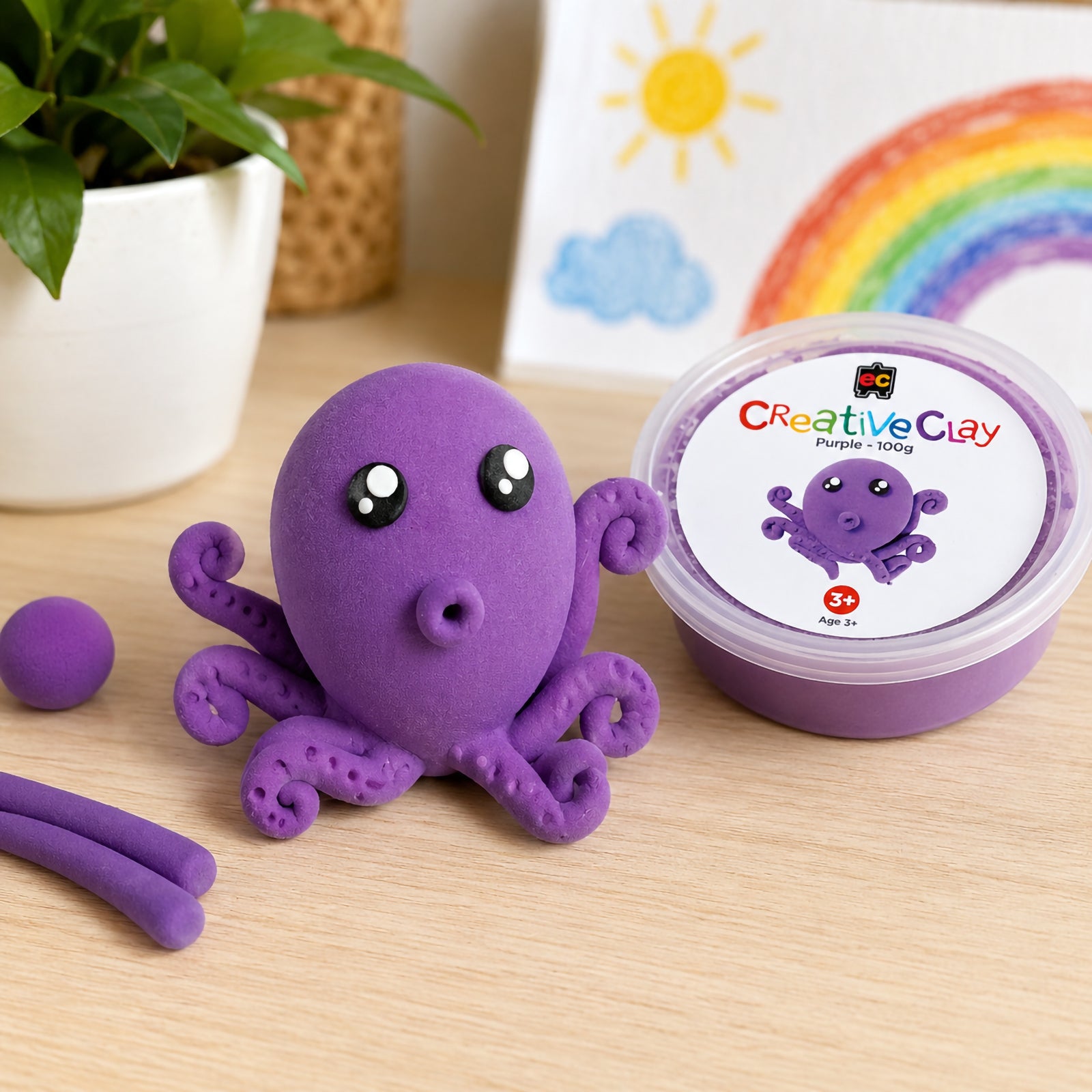 Educational Colours CreativeClay Purple 100g container displayed beside a completed octopus model and crafting materials. The scene showcases the product packaging, vibrant colour and inspiration for imaginative marine themed creations.