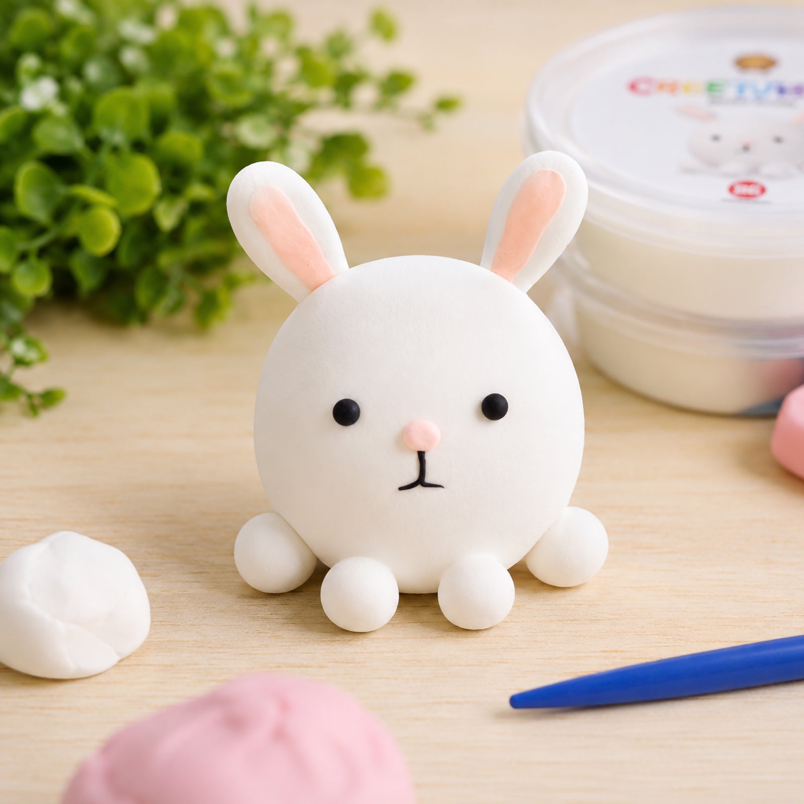 Finished white rabbit sculpture created from CreativeClay with soft pink ear details and simple facial features. The image demonstrates the clay's ability to hold shape and create charming decorative models with a smooth finish.