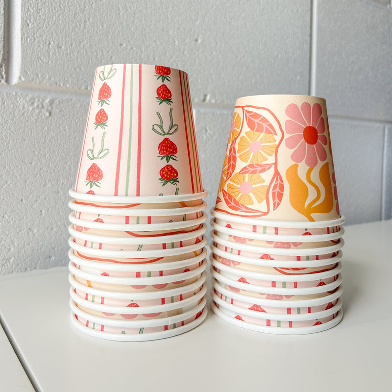Two stacks of Creative Cafe Co 8oz printed takeaway cups in red and orange designs against a white wall