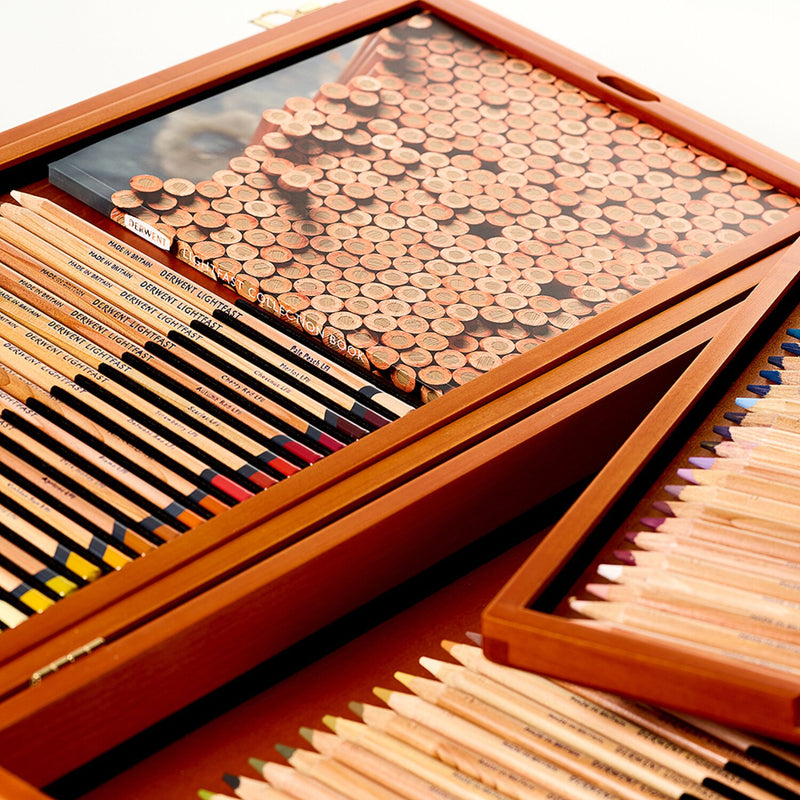 Close view of the open Derwent Lightfast 100 wooden box, showing trays of pencils and a grid of coloured pencil ends