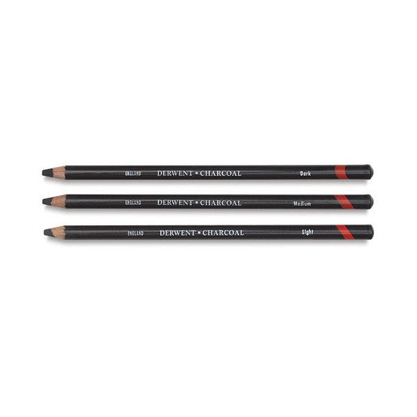 Three Derwent Charcoal pencils labelled Dark, Medium and Light laid side by side on white, showing the Medium grade alongside the other two grades.