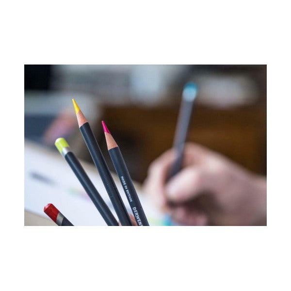 Close-up of a hand drawing with Derwent Procolour pencils, three sharpened pencils in focus in the foreground