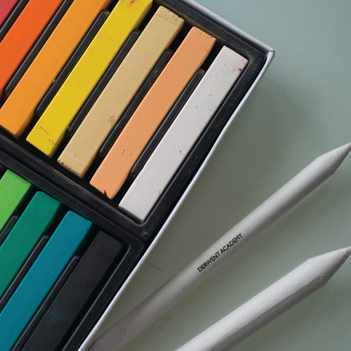Derwent Academy Soft Pastels Assorted Pack of 12. Hand blending Derwent Academy soft pastels on textured art paper showing smooth colour gradients.