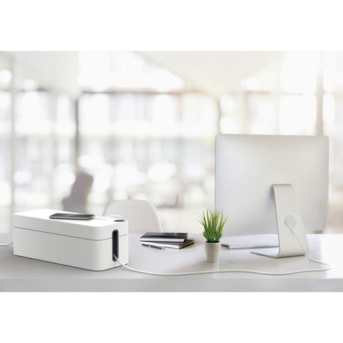 Grey Durable cable box on a white desk beside a monitor, pot plant and stacked books
