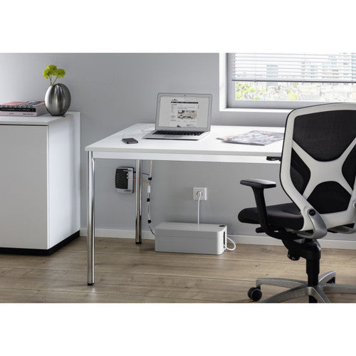 Durable grey cable box on the floor under an office desk with a mesh chair and laptop