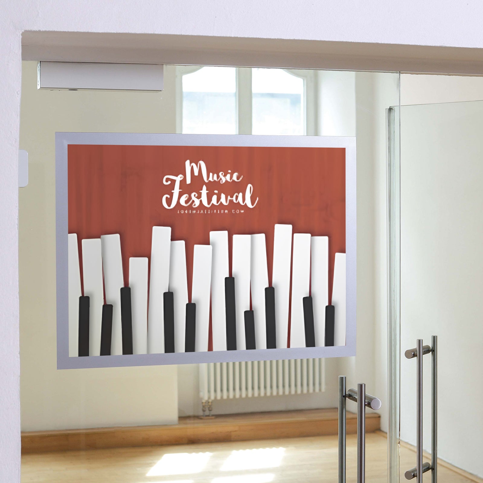 Durable DURAFRAME Poster A2 Silver mounted to a glass entrance door displaying a promotional music festival poster. The silver magnetic frame provides a premium presentation while allowing the advertisement to remain visible through the glass in a modern commercial environment.
