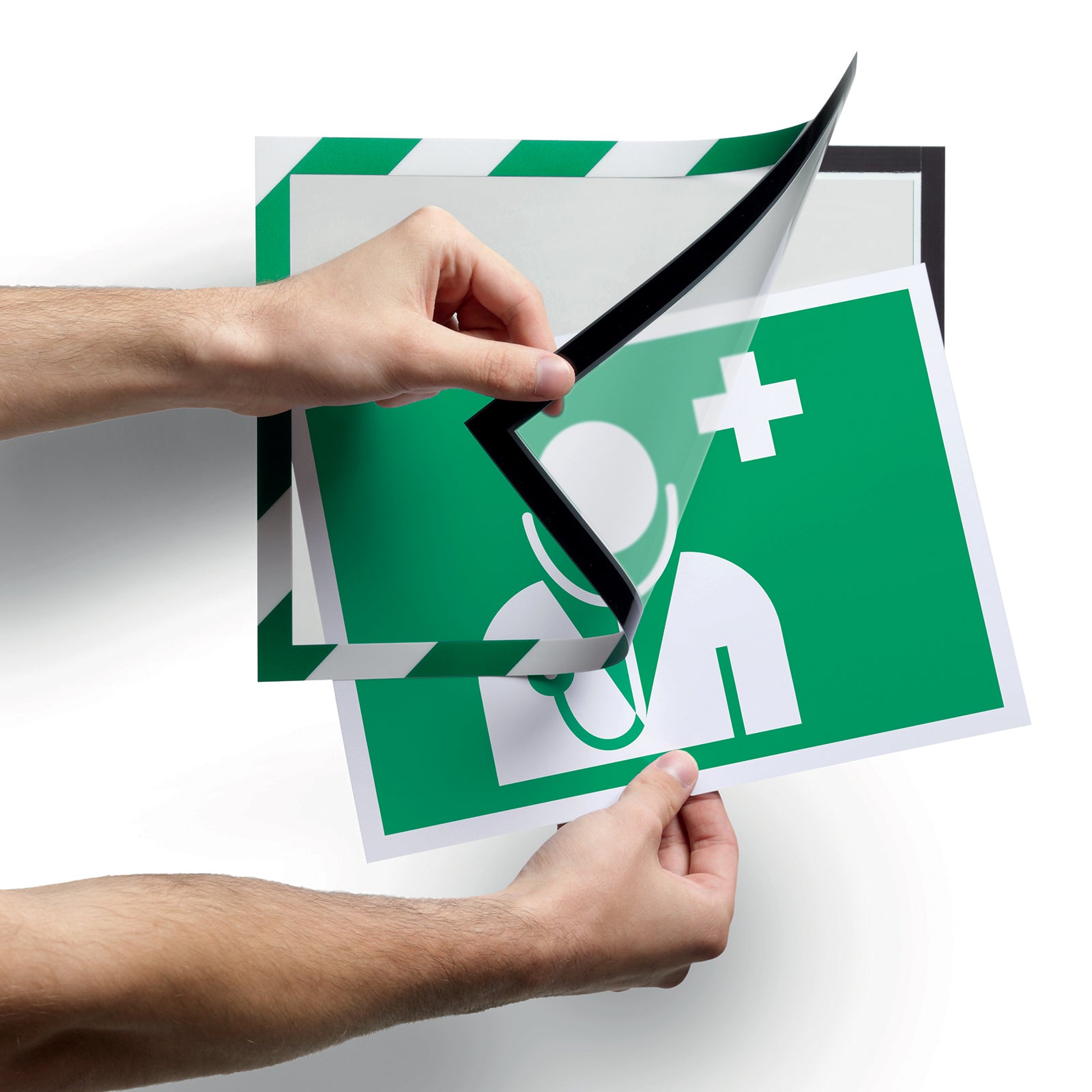 Close up of the Durable DURAFRAME Security Green White magnetic frame being opened to insert a first aid notice. The fold back design allows fast updates for changing workplace information.