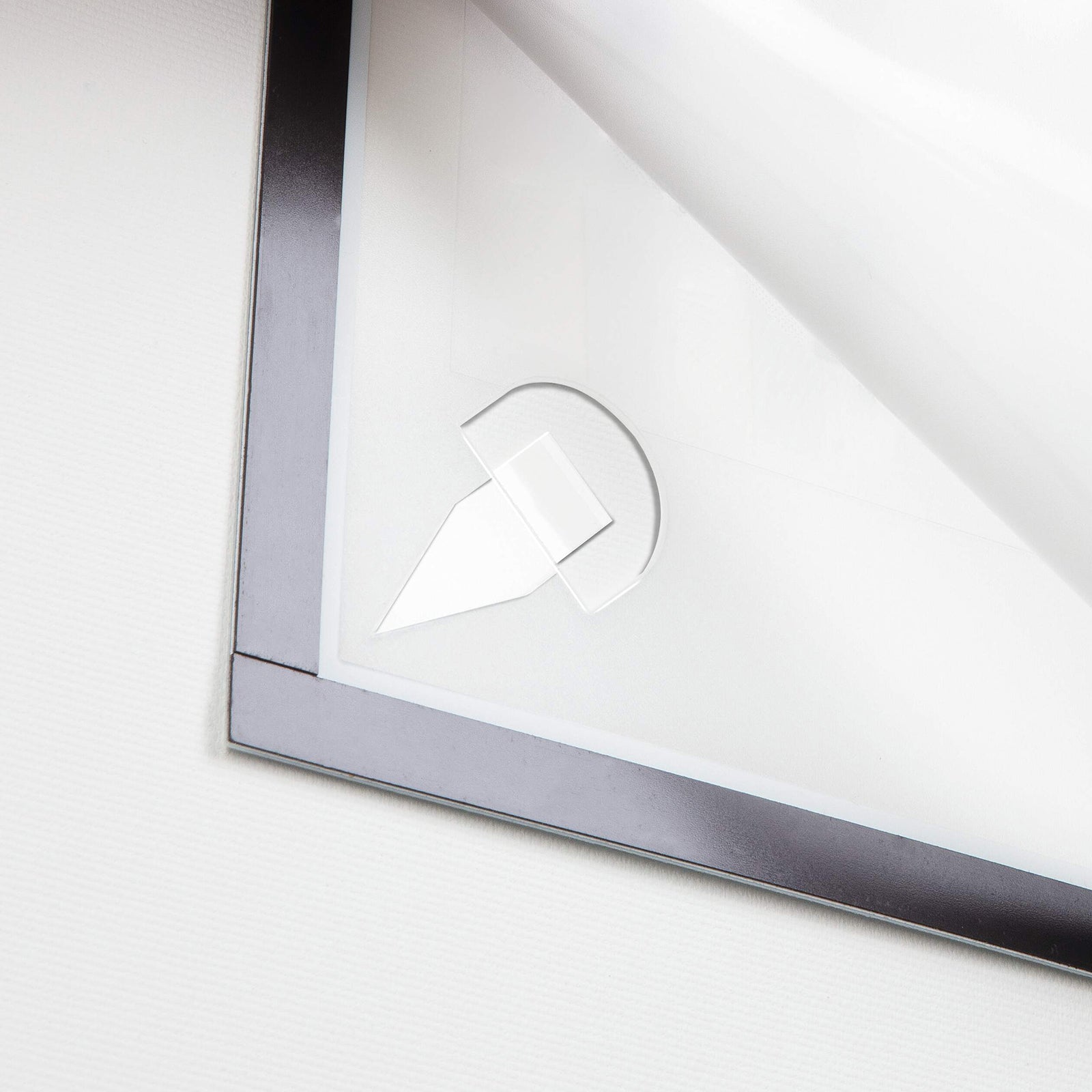 Detailed close up showing the rear corner of the Durable DURAFRAME Wallpaper Frame with the protective backing partially removed from an adhesive strip. The image demonstrates the simple installation process and residue free mounting system.