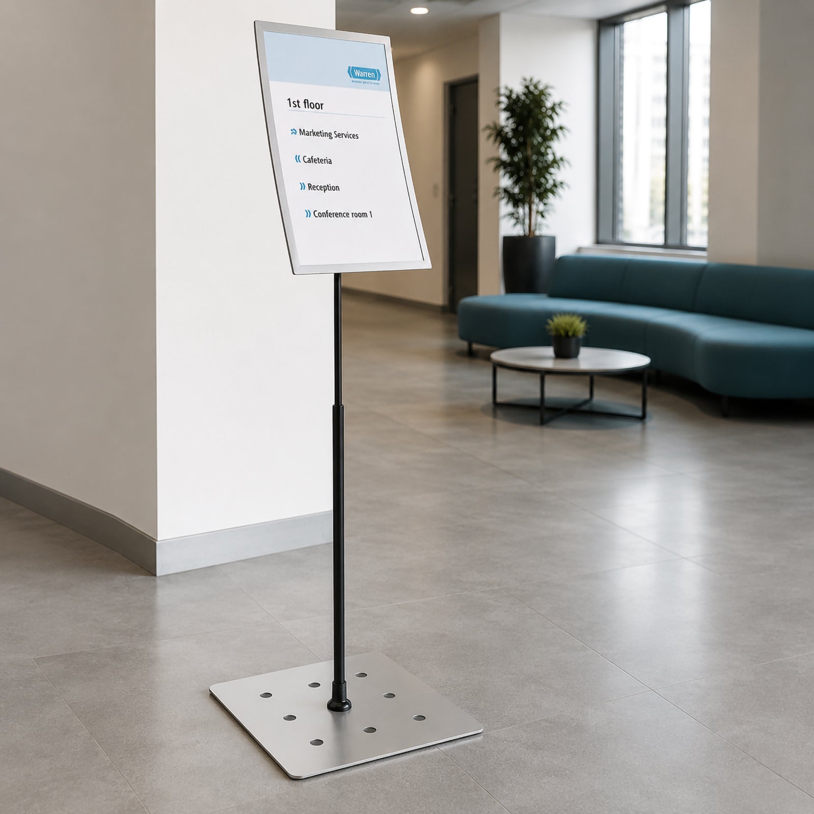 Wide lifestyle view of the Durable Duraview A3 Floor Stand placed in a corporate reception area with lounge seating and large windows, demonstrating its professional appearance for wayfinding, visitor information and public notices.