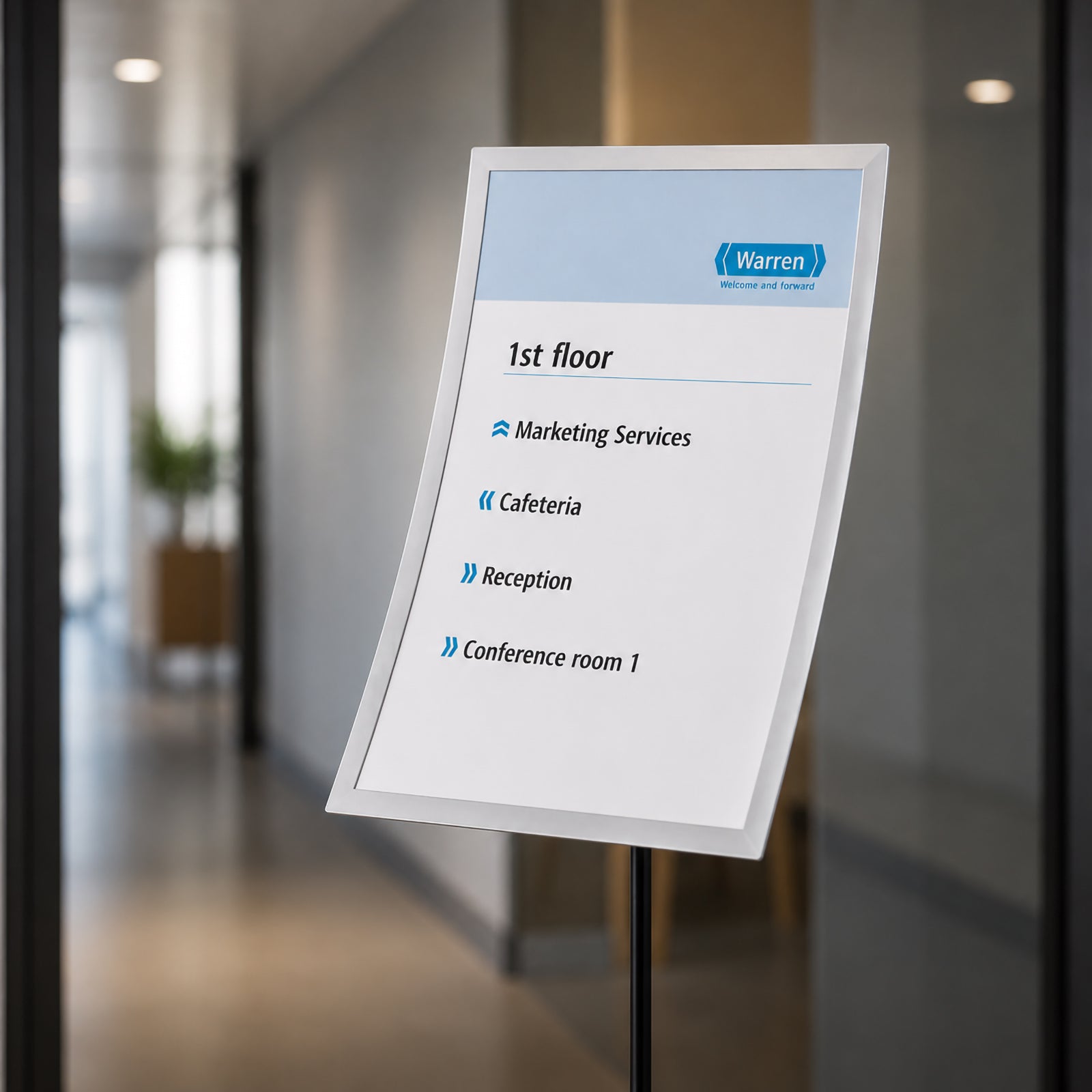 The Durable Duraview A3 Floor Stand positioned in a modern office corridor displaying a directional information sign. The adjustable display panel presents visitor guidance clearly while complementing contemporary commercial interiors.