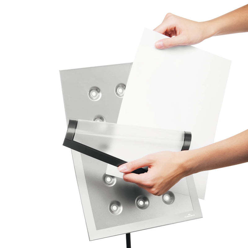 Hands inserting an A4 document into the detachable DURAFRAME Magnetic display frame on the Durable Duraview Floor Stand, demonstrating the simple and efficient document replacement process.