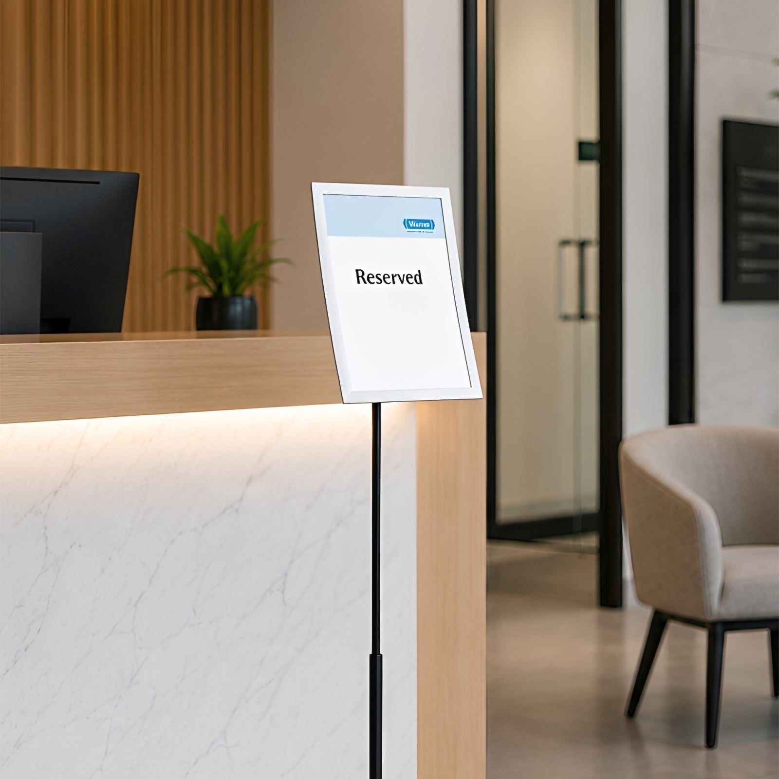 The Durable Duraview Floor Stand A4 Silver positioned beside a contemporary reception desk displaying a reserved sign, demonstrating its professional appearance for visitor management and customer service environments.