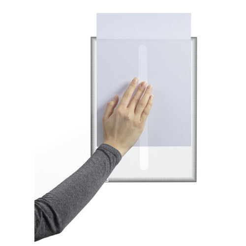Hand smoothing a grey static cling Duraframe Info Frame onto glass while an A4 sheet slides in from the top