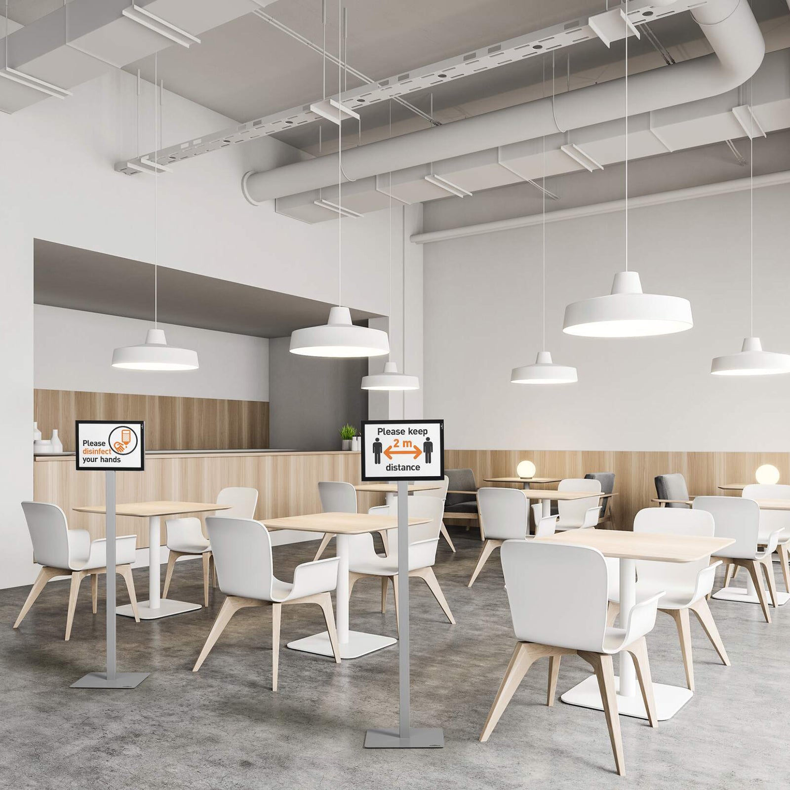 The Durable Info Stand Floor Basic A4 Silver displayed throughout a modern office cafeteria with hygiene and distancing signs positioned between seating areas. The freestanding double sided information displays provide clear visitor guidance while complementing the clean contemporary workspace.