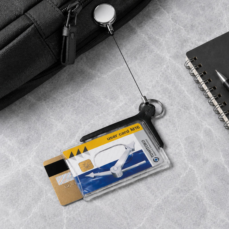 Deluxe Pro Duo card holder with two cards on a grey stone desk beside a notebook and black bag