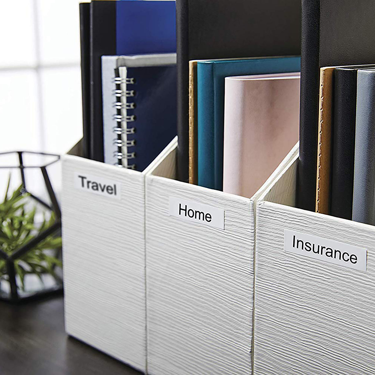 Black on white D1 labels on magazine files marked Travel, Home and Insurance