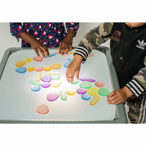 Child holding a clear rainbow pebble showing size relative to hand