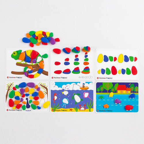 Close-up of Rainbow Pebbles activity cards and assorted pebbles in six colours on a flat surface