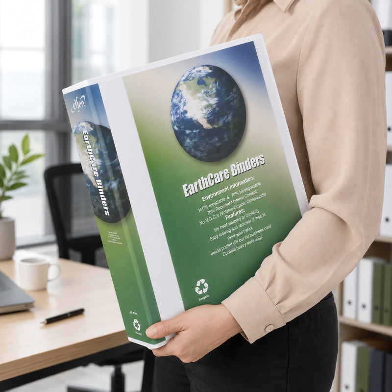 A professional office lifestyle image showing a person holding the Earthcare A4 4D Ring Insert Binder with a customised cover while standing beside a modern workstation. The white binder is displayed prominently, highlighting its professional appearance, large 40mm spine and suitability for transporting presentations, reports and business documents.
