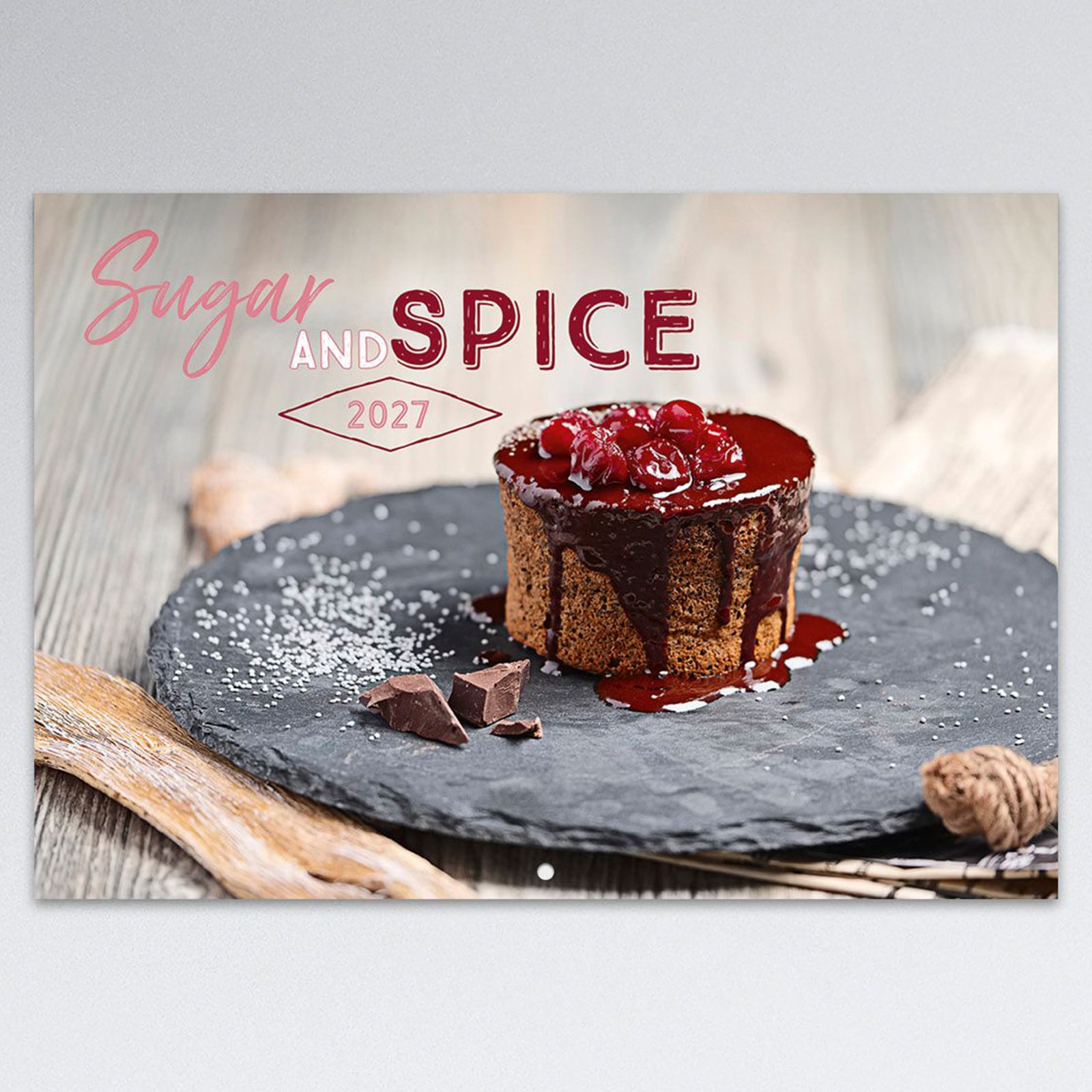 Close up of the Sugar and Spice 2027 front cover featuring an indulgent chocolate dessert with cherry topping, highlighting the premium food photography and stylish stitched A4 calendar design.