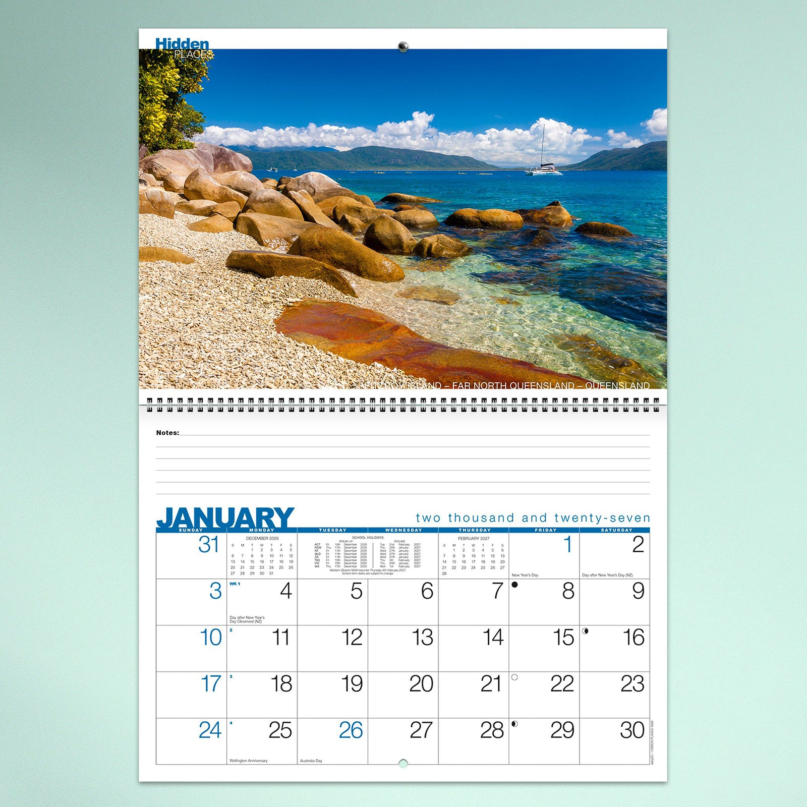 A January calendar page featuring crystal clear tropical waters, rocky shoreline and sailing boat in Far North Queensland. The bright coastal image is paired with a spacious monthly planner and notes section.