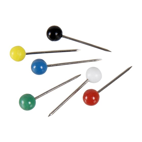 Seven Esselte map pins laid out, small round heads in black, yellow, blue, white, green and red on fine steel pins