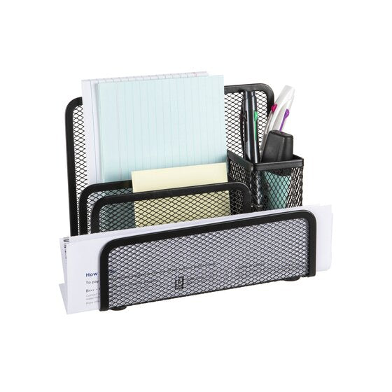The mesh desk organiser holding a notepad, sticky note pads, window envelopes and coloured pens in the cup