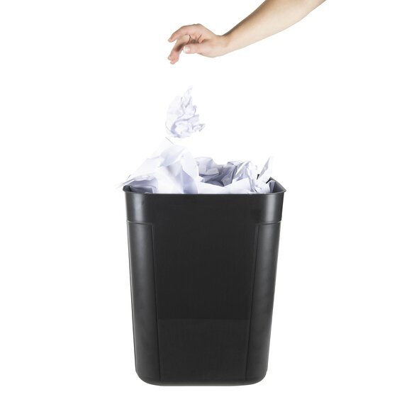 A hand dropping screwed up white paper into the black Esselte SWS waste bin