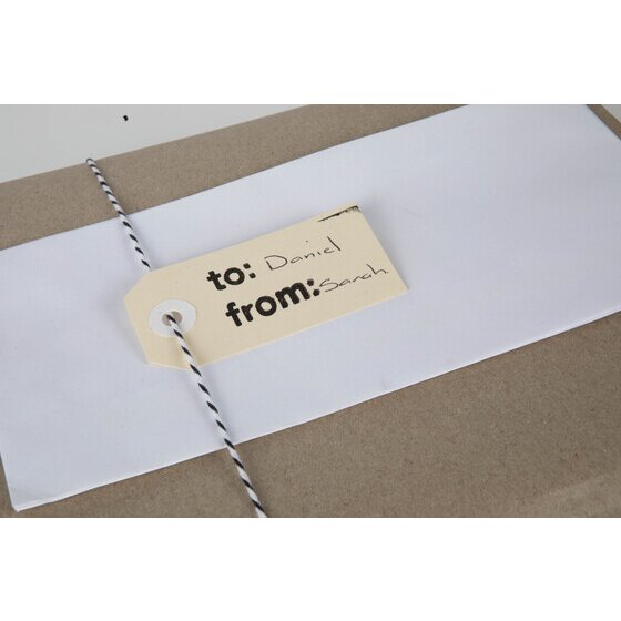 Small buff tag handwritten to Daniel from Sarah, tied with black and white string to a wrapped parcel