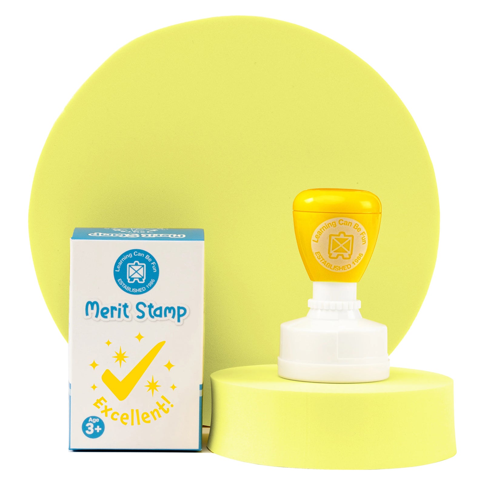 Retail packaging and Excellent Merit Stamp displayed together on a presentation platform. The product packaging highlights the cheerful reward design, making it ideal for motivating learners and recognising outstanding work.