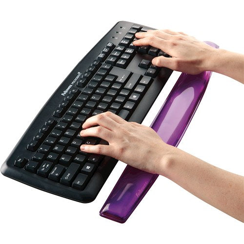 Hands typing on a black keyboard with the purple Crystal gel wrist rest in front of the keys