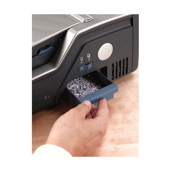 Hand sliding out the blue chip tray on the side of the binder, full of punched paper chips
