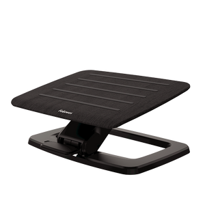 Fellowes Hana foot support with a black wood grain platform tilted on its black steel base, seen from a front corner