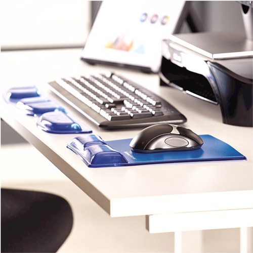 Desk with a blue Health-V mouse pad and blue gel keyboard rest beside a keyboard and printer