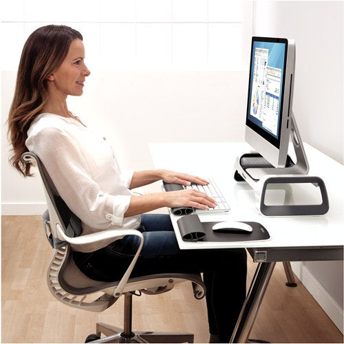 Woman typing at a white desk with her screen raised on the I-Spire monitor lift