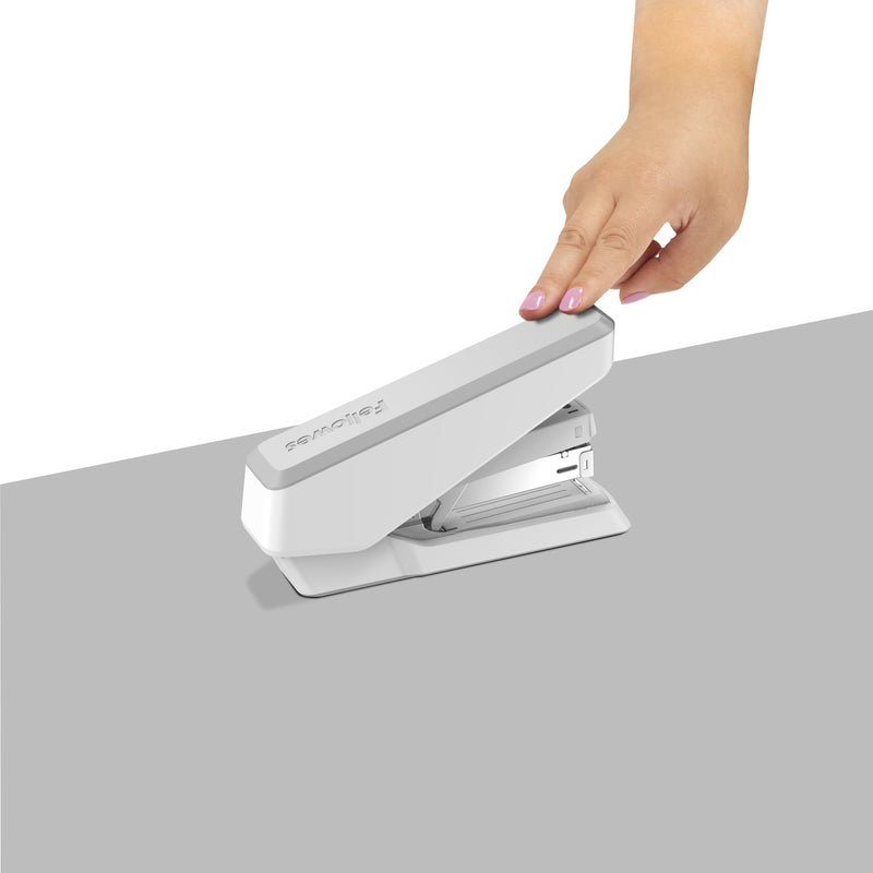 Hand pressing down on a white LX870 stapler resting on a grey surface