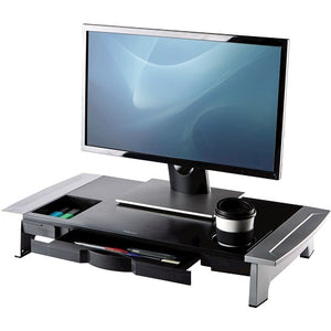 Office Suites premium monitor riser in black and silver with a monitor on top, drawer open and a cup in the holder
