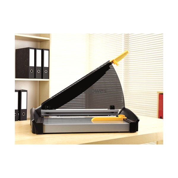 Plasma A3 guillotine on an office desk beside a shelf of lever arch files, arm raised and clamp open