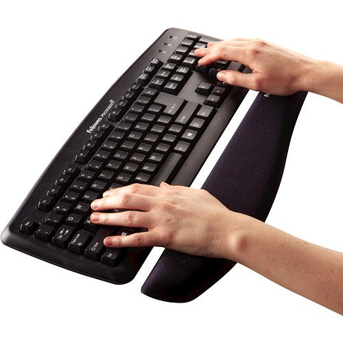 Hands typing on a black keyboard with the wrists resting on the black PlushTouch foam support in front