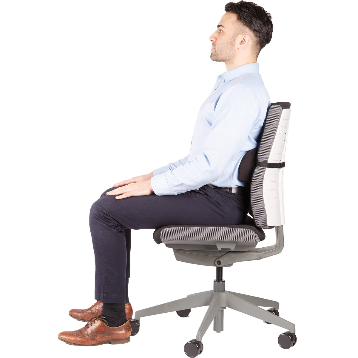 Man sitting upright on an office chair with the black lumbar cushion between his lower back and the backrest