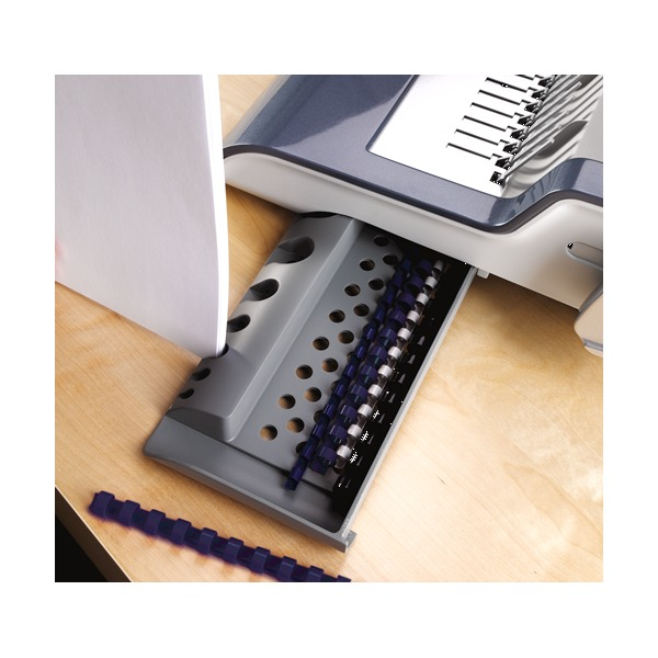 Quasar-E 500 storage tray pulled out on a wooden desk, holding blue plastic combs in its slots